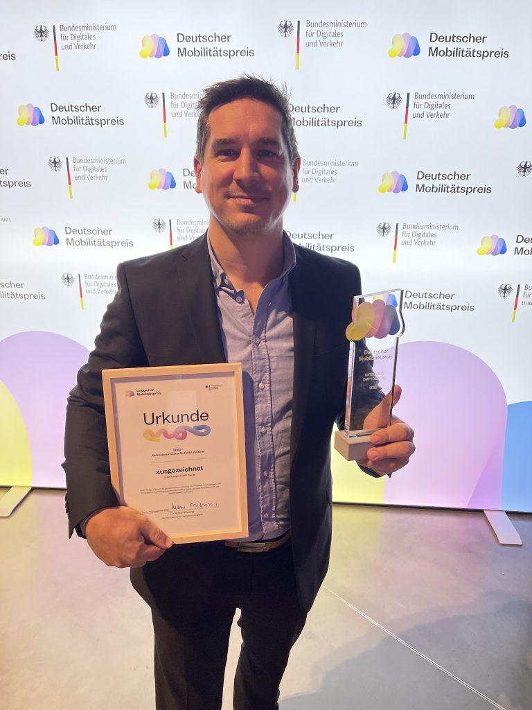 Ralf Elter mit Urkunde und Trophäe des Deutschen Mobilitätspreises 2023